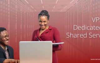Two professionals discussing hosting solutions on a laptop with a server room background, highlighting VPS vs Dedicated vs Shared Servers.